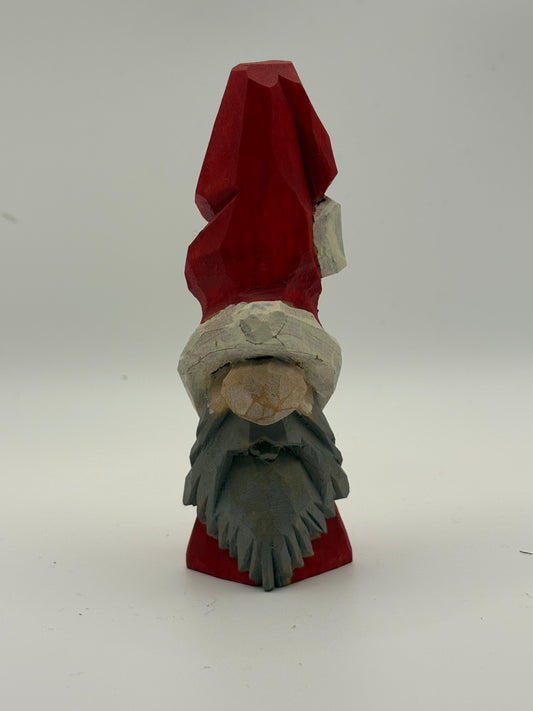 Wooden gnome figurine with a red hat and beard on a white background